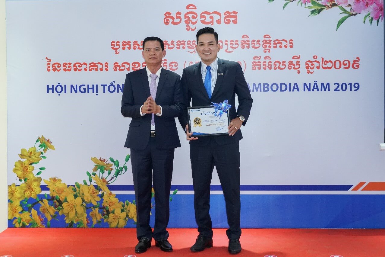 លោក Nguyen Van Minh -ស​មា​ជិក​ក្រុម​ប្រឹ​ក្សា​ភិ​បាល​ធនា​គារ សា​ខម​ប៊ែង (ខេម​បូ​ឌា) ភី​អិល​ស៊ី ប្រ​គល់​ប័ណ្ណ​សរ​សើរ​អង្គ​ភាព​ឆ្នើម​ប្រ​ចាំ​ឆ្នាំ​២០១៩ ដល់​សា​ខា​ច្បា​រអំ​ពៅ - តំ​ណាង​សា​ខា​ច្បារ​អំ​ពៅ លោក​នា​យក​សា​ខា គីម មក​រា ។